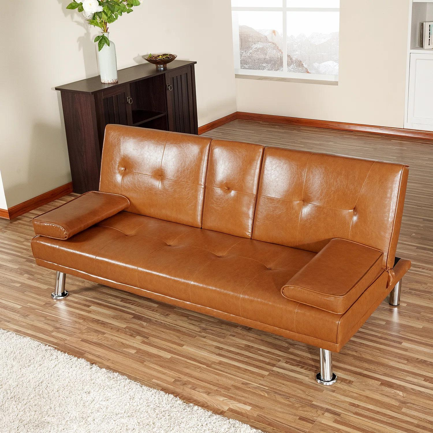 Couch Bed Futon Sleeper Sofa for Living Room | Tan Faux Leather from AHF Depot - Tan leather futon with center cupholders displayed against oakwood floor in a modern living room scene positioned in the center of the room.